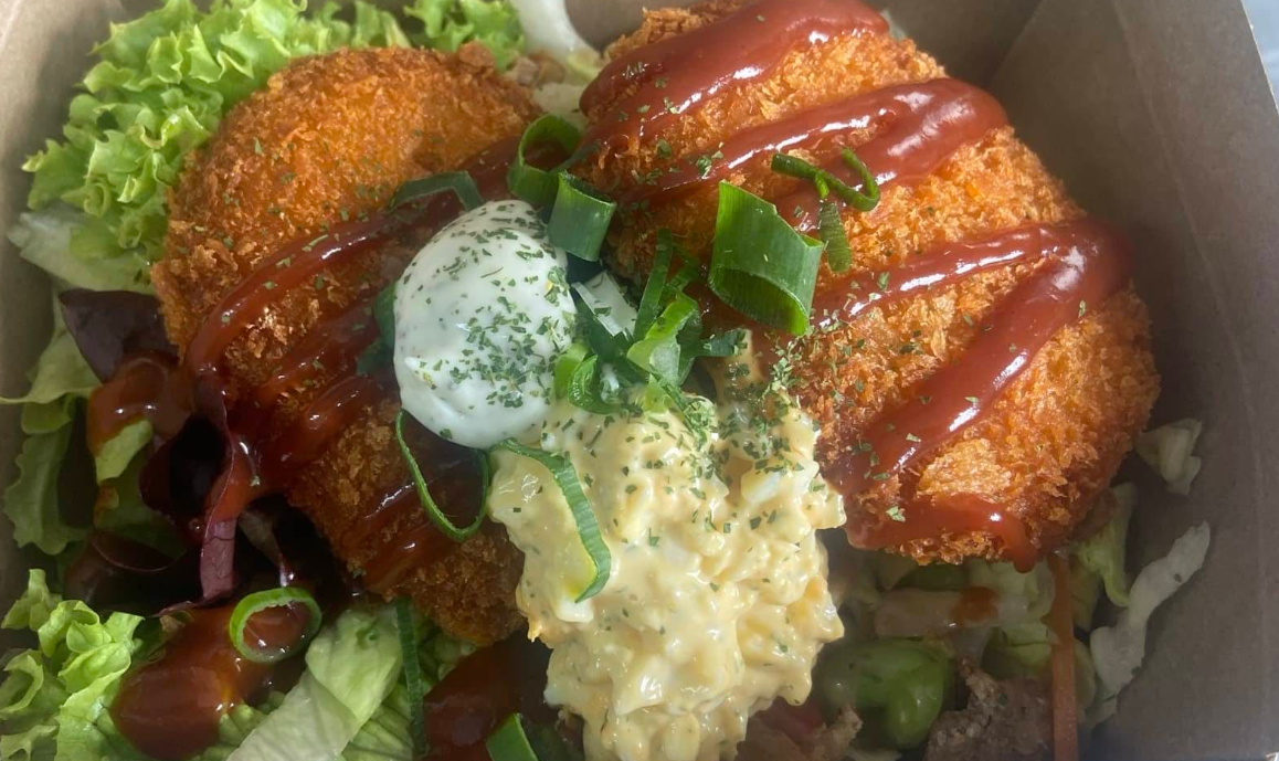 Golden crumbed chicken with glossy sauce, salad and creamy dressing