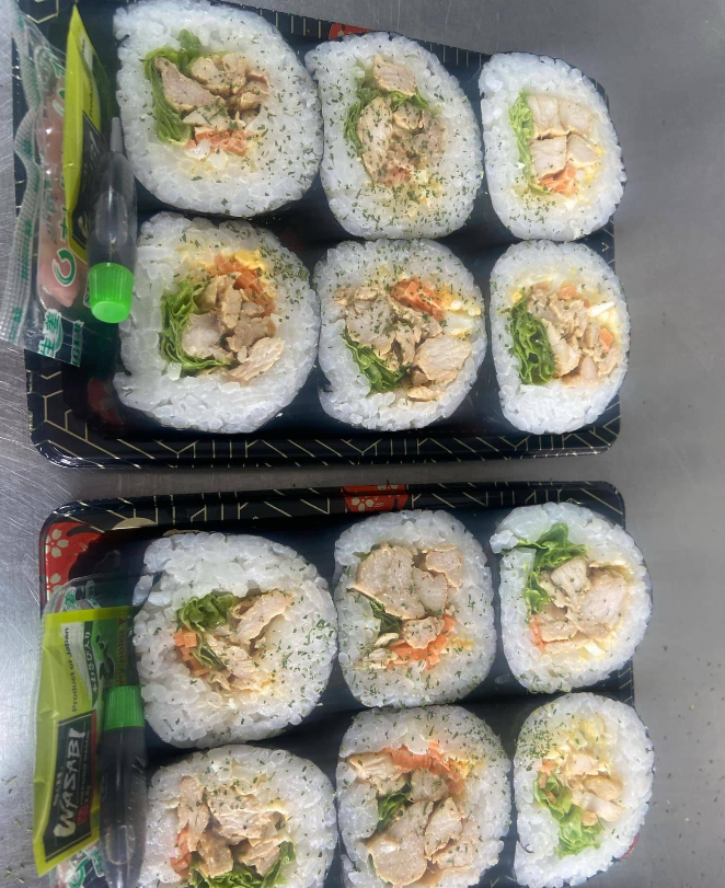 Takeaway trays of sushi rolls with vegetables and filling